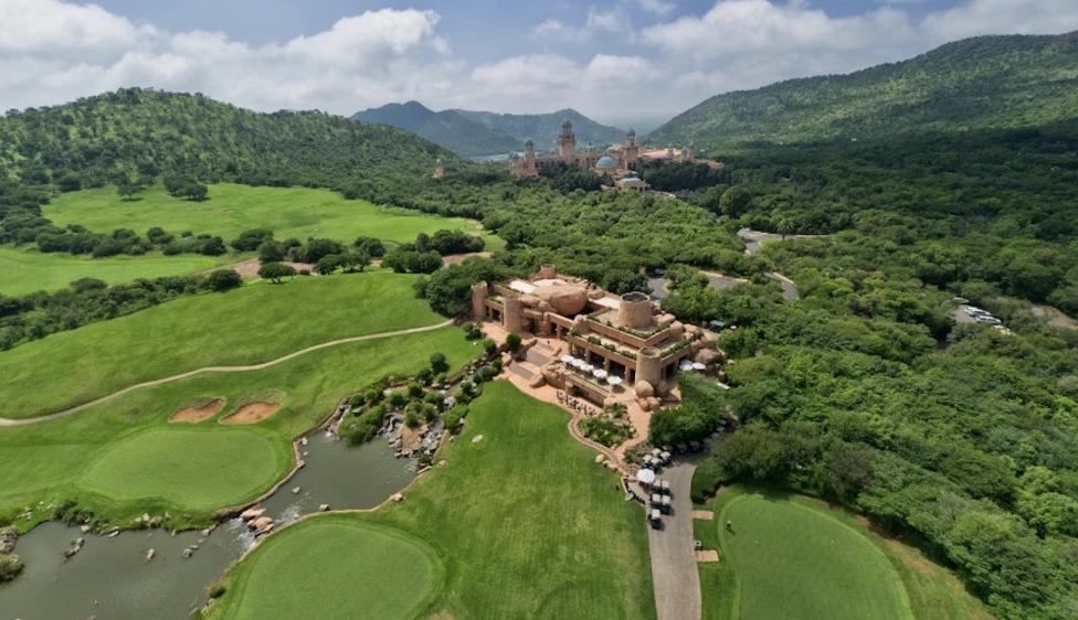 Día 6 - Lost City y Safari Vista aérea del Lost City Golf Club con casa club, greens, lagos y montañas.