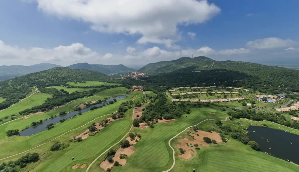 Lost City Golf Club Vista aérea del Lost City Golf Club con lagos, calles verdes, búnkeres y montañas.