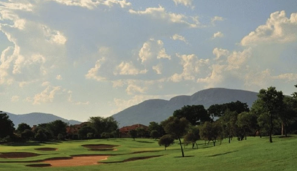 Campo del Pecanwood Country Club con varios búnkeres, árboles y montañas al fondo.