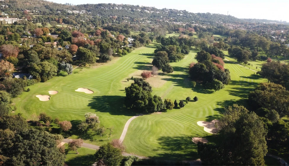Royal Johannesburg Country Club Vista aérea del Royal Johannesburg Country Club con calles verdes, búnkeres y árboles.