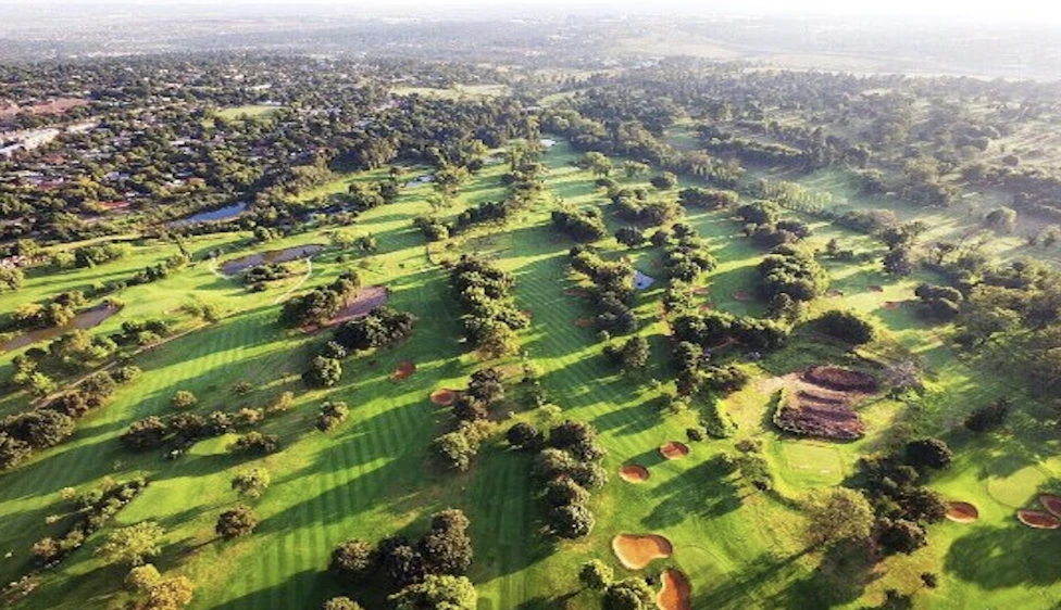 Vista aérea amplia del Royal Johannesburg Country Club con calles verdes, árboles y búnkeres.