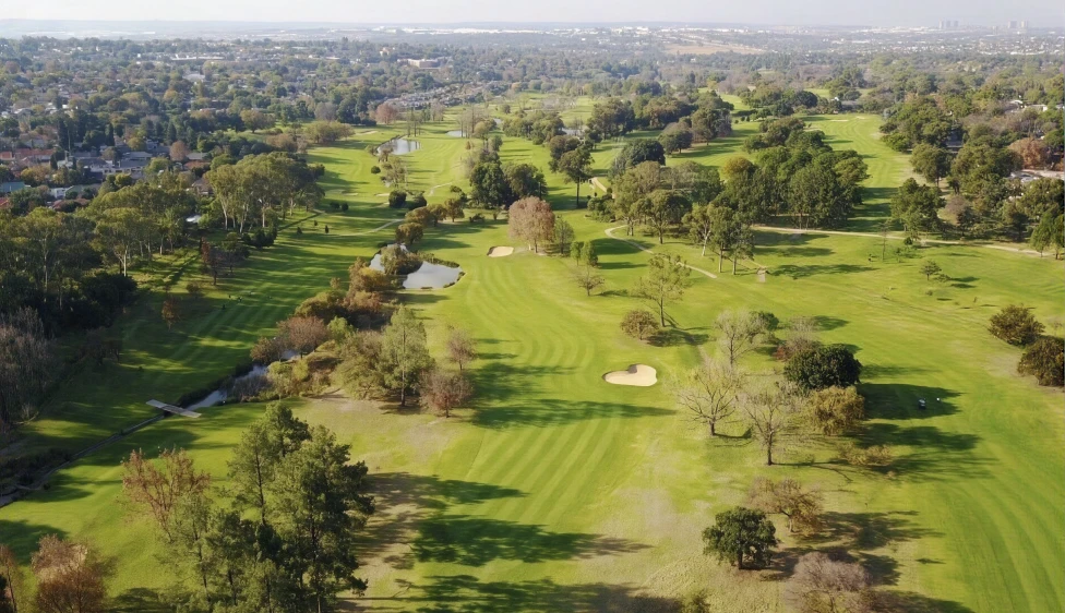 Vista aérea del Royal Johannesburg Country Club con lagos, calles verdes, árboles y búnkeres.